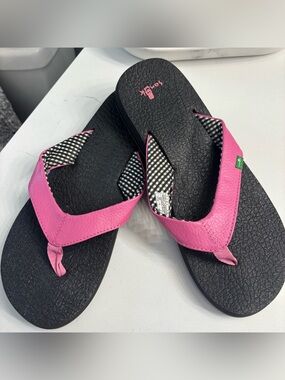 Classic black Sanuk flip flops. Striped fabric on the straps with pink strap.